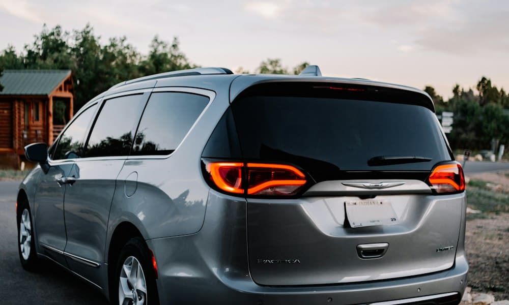 Silver family minivan parked outside a cabin