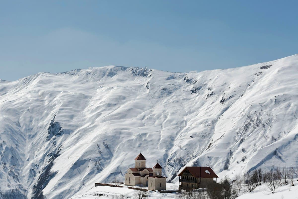 Church at Gudauri backed by snow-covered Caucasus peaks